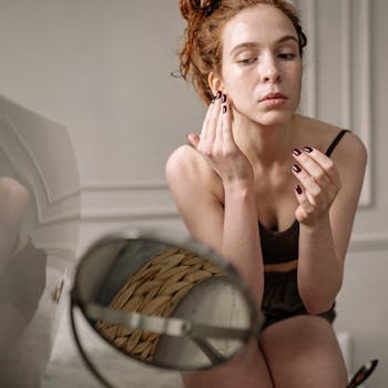 Young woman practicing her skincare routine at home, focused on facial treatment.